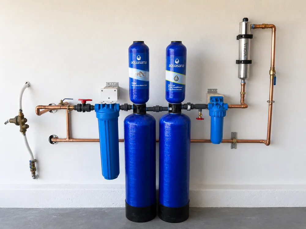 A whole-house water filtration system: twin Aquasana filter and conditioner tanks with pre- and post-filter housings, a UV steriliser and copper pipework.